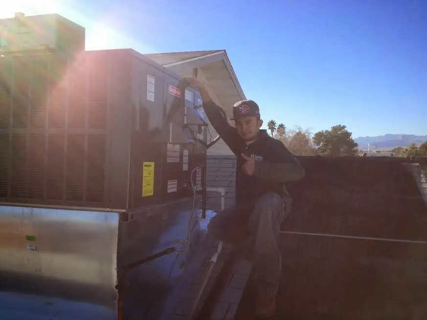 HVAC technician performing AC Tune-Up on a rooftop unit in Twin Lakes